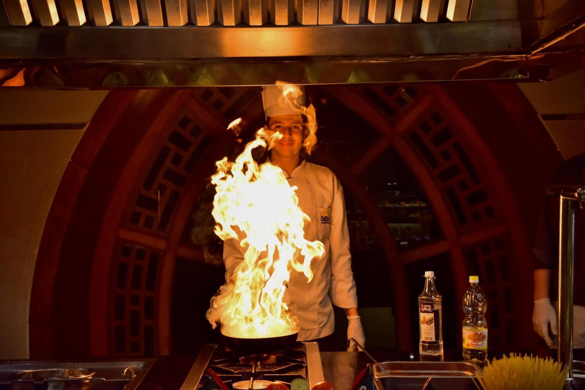 The Grand Hotel Sharm El Sheikh Exterior foto A chef cooking with a flaming wok